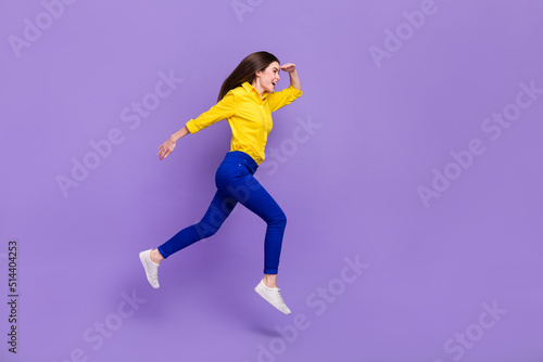 Full length body size view of attractive cheery girl jumping looking copy space isolated over bright violet purple color background