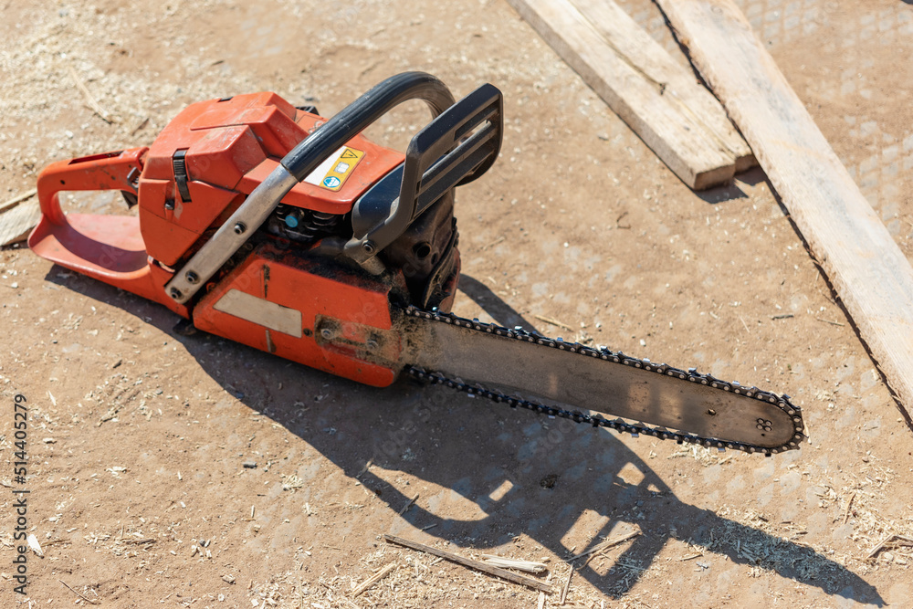 Chainsaw at the construction site. Reliable mobile tool for cutting boards and wooden blocks.
