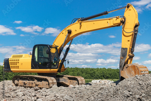 Wallpaper Mural Powerful industrial excavator in a quarry against a blue cloudy sky. Loading crushed stone and soil with an excavator. Earth-moving equipment and earthworks. Torontodigital.ca