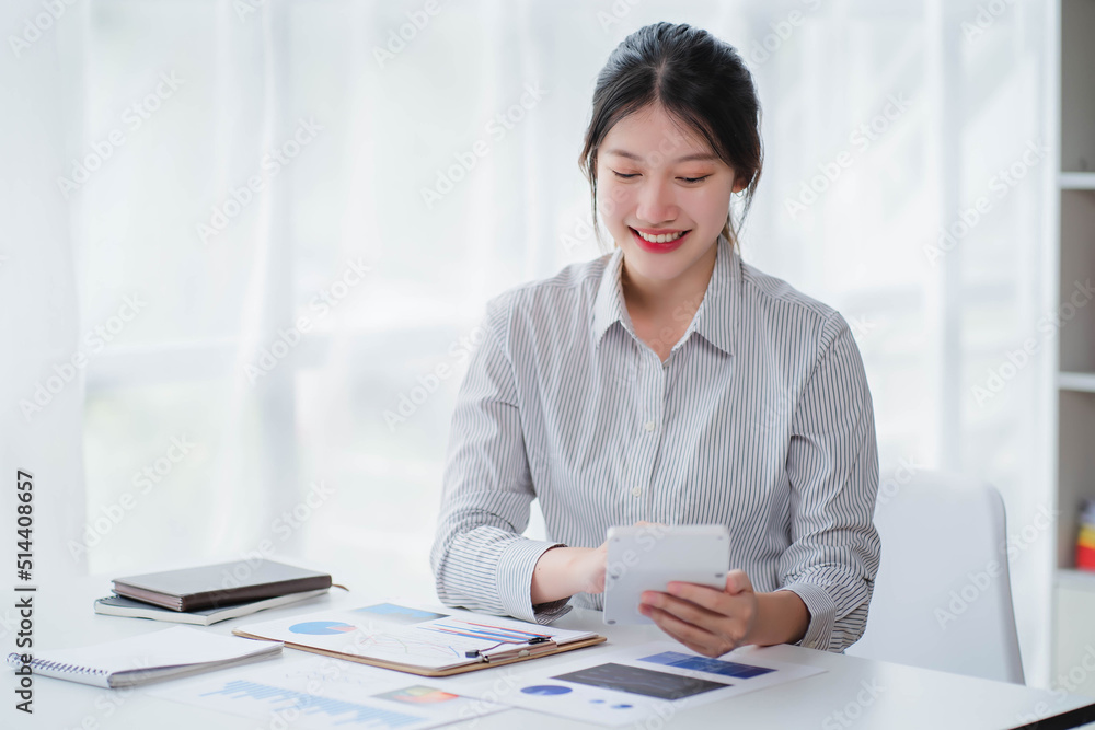 Young asian businesswoman beautiful charming smiling and talking on the mobile phone in the office Young asian businesswoman beautiful charming smiling and talking on the mobile phone in the office