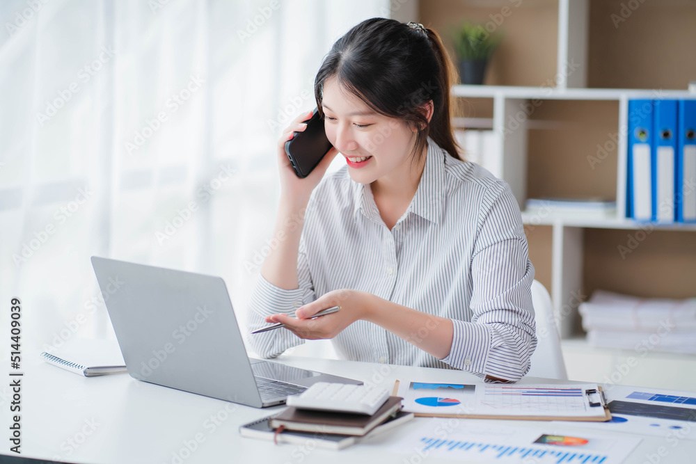Young asian businesswoman beautiful charming smiling and talking on the mobile phone in the office Young asian businesswoman beautiful charming smiling and talking on the mobile phone in the office