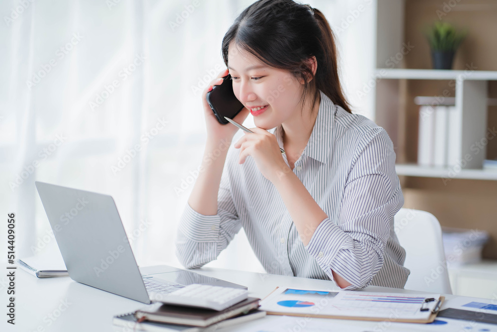Young asian businesswoman beautiful charming smiling and talking on the mobile phone in the office Young asian businesswoman beautiful charming smiling and talking on the mobile phone in the office