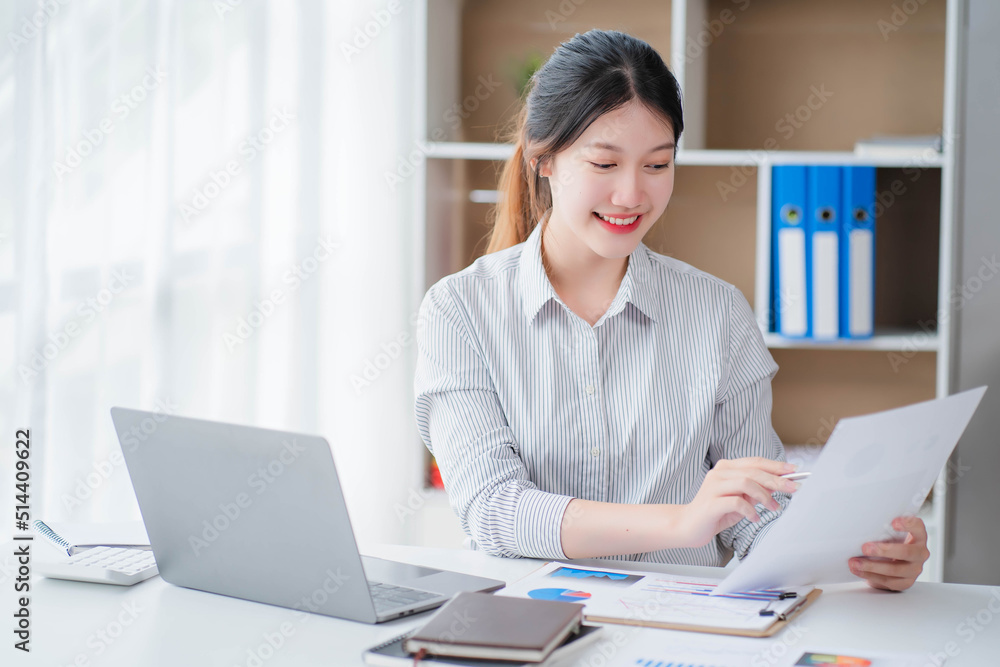 Young asian businesswoman beautiful charming smiling and talking on the mobile phone in the office