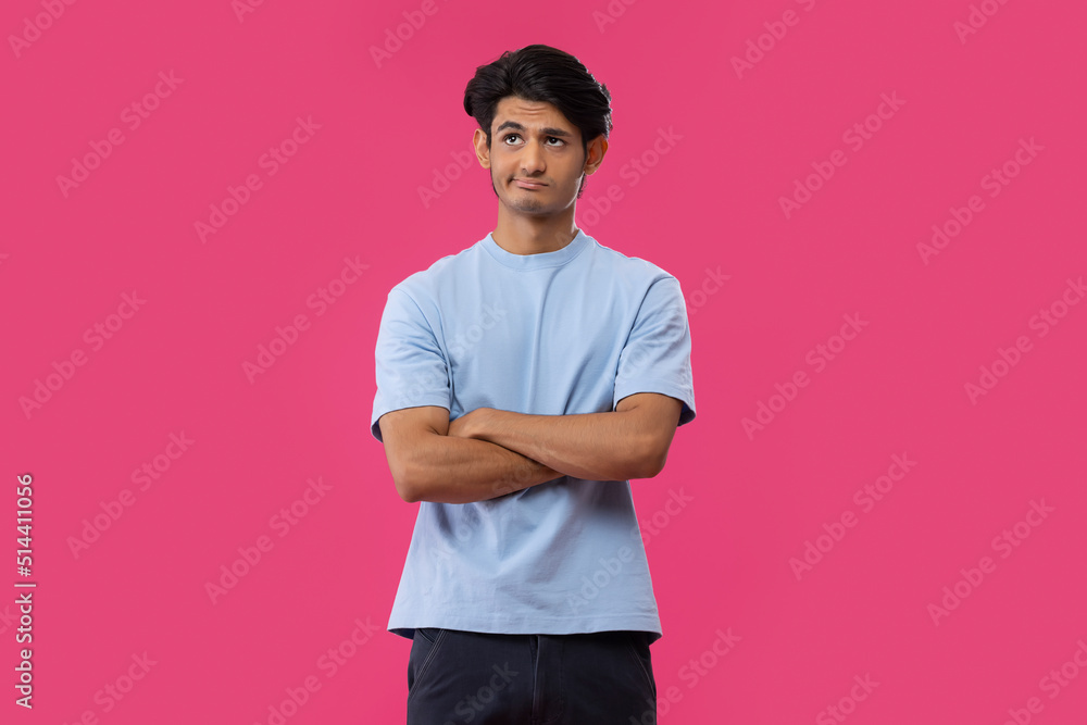 Portrait of a sad teenage boy standing against blue background Portrait of a sad teenage boy standing against blue background