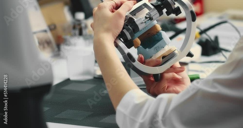 Dental technician makes a plaster cast of jaw models in an articulator. Production of a dental implant in a dental laboratory
