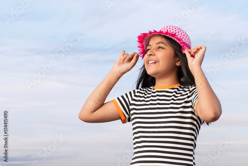 Portrait of little girl with hat against blue sky on a sunny day 