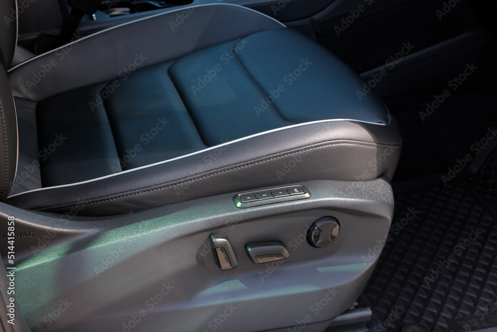 Obraz premium Detail of new modern car interior, Focus on seat adjust switch. The driver seat of a luxury business class car. Car seat manual adjust stick panel to control seat position in passenger car.
