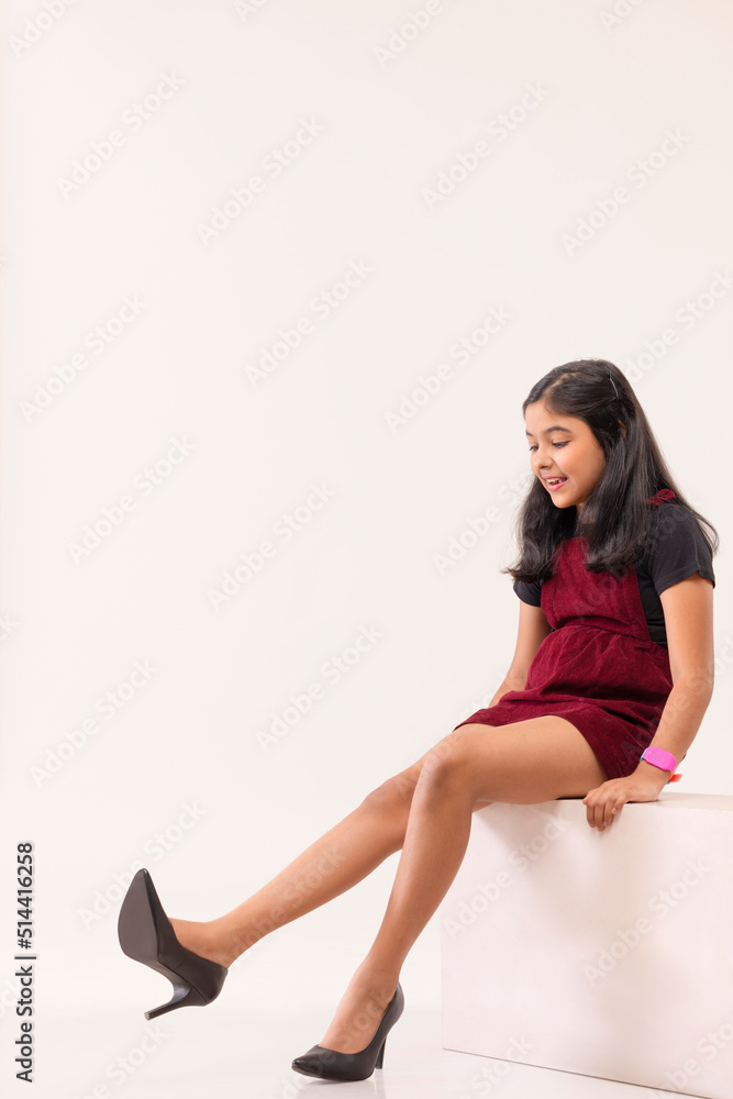 Portrait of little girl trying on high heel shoes Stock Photo Adobe Stock