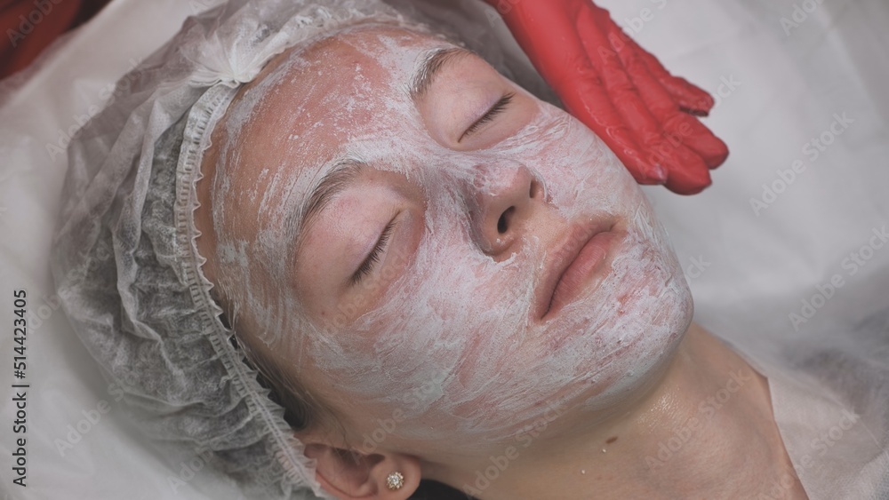 Application of a cream mask on the face of a girl with problem skin in the salon. Application of a cream mask on the face of a girl with problem skin in the salon.