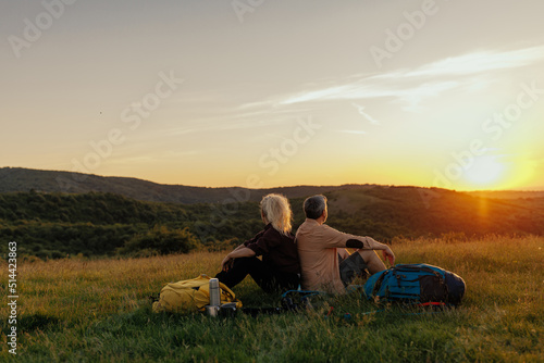Mid adult couple resting after walk at the foot of the mountain