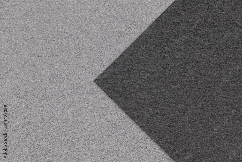 Texture of black and gray paper background, half two colors with arrow, macro. Structure of dense craft grey cardboard. Texture of black and gray paper background, half two colors with arrow, macro. Structure of dense craft grey cardboard.