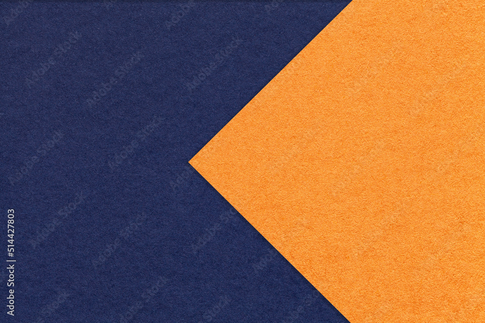 Texture of navy blue and orange paper background, half two colors with arrow, macro. Structure of dense craft cardboard Texture of navy blue and orange paper background, half two colors with arrow, macro. Structure of dense craft cardboard