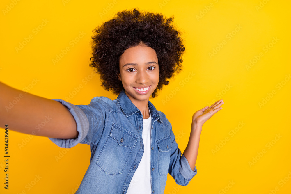 Self-portrait of beautiful trendy cheerful teen age girl showing copy space blog isolated over bright yellow color background Self-portrait of beautiful trendy cheerful teen age girl showing copy space blog isolated over bright yellow color background