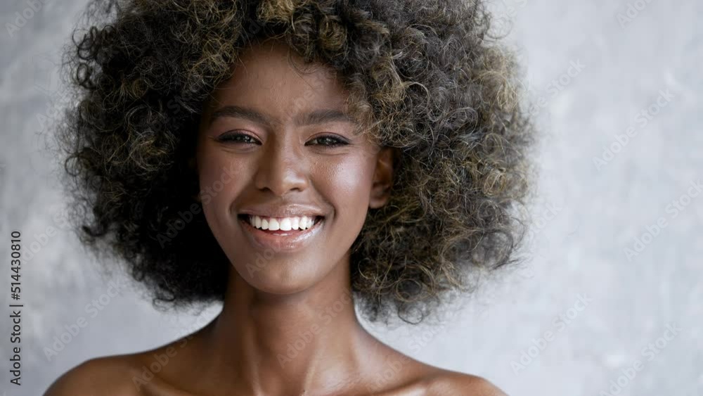 Black woman with curly hair looking at camera Black woman with curly hair looking at camera