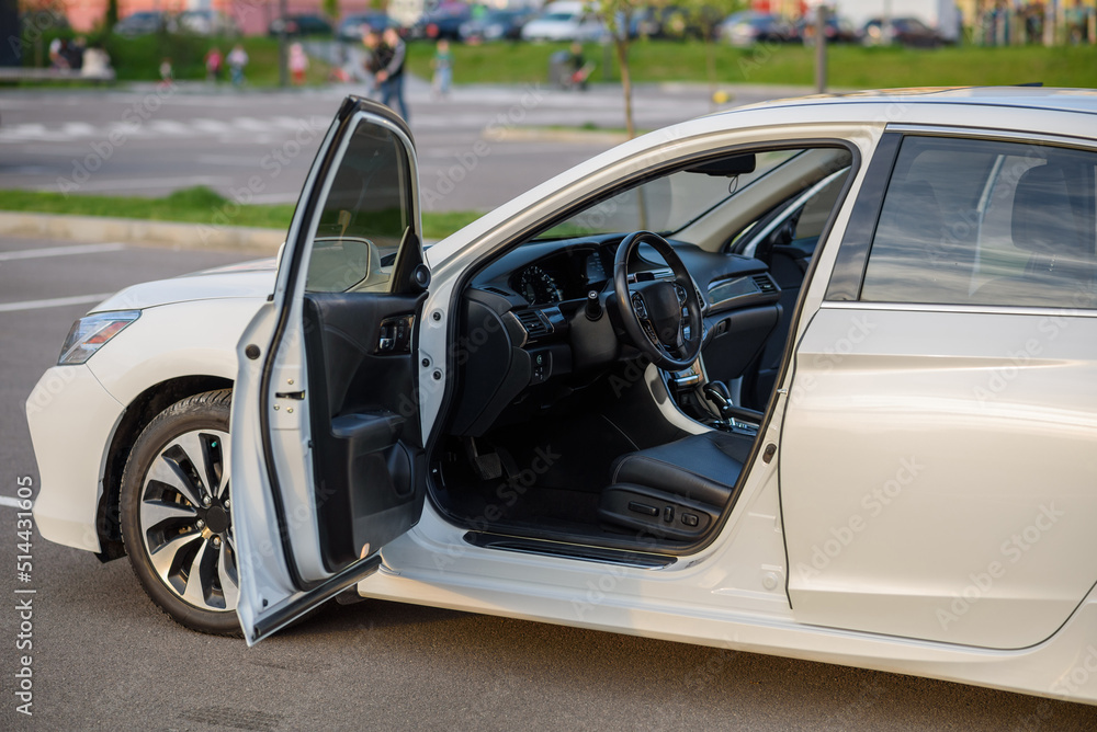 Side view of the open driver's door, mirror, dashboard of the car. Left