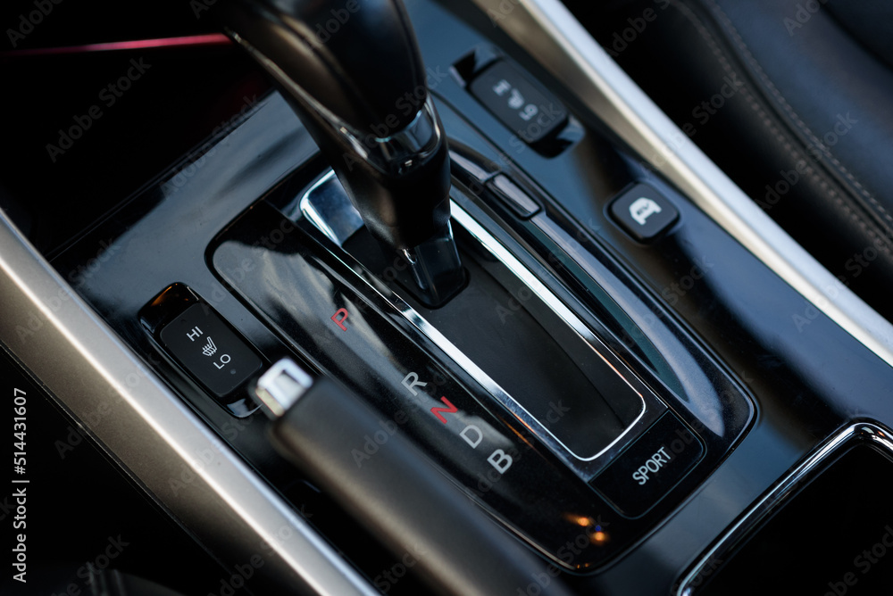 Gear shift stick into P position, (parking) symbol in automatic transmission car. Modern automatic gearbox hybrid car. Close up of the gear box transmission handle. Car detailing. Interior car inside. Gear shift stick into P position, (parking) symbol in automatic transmission car. Modern automatic gearbox hybrid car. Close up of the gear box transmission handle. Car detailing. Interior car inside.