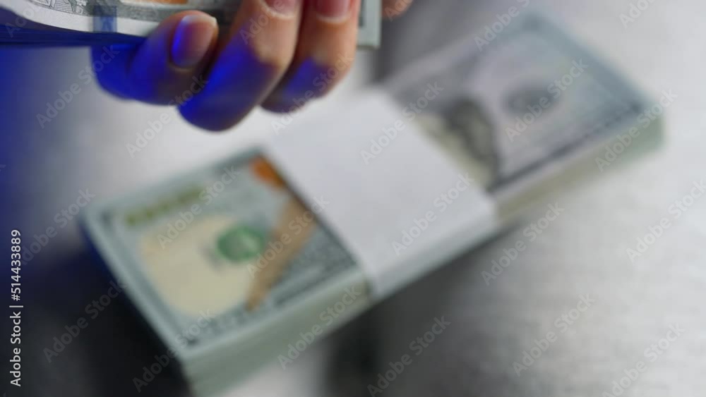 Hands checks US Dollar bills or counting in cash against the backdrop of police car lights