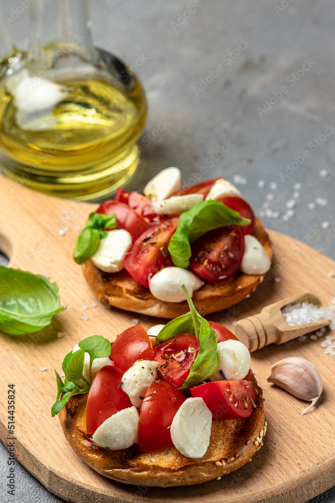 Open sandwiches with cherry tomatoes, mini mozzarella, fresh basil leaves, caprese on bread, Traditional italian appetizer or snack, antipasto. banner, menu, recipe place for text, top view Open sandwiches with cherry tomatoes, mini mozzarella, fresh basil leaves, caprese on bread, Traditional italian appetizer or snack, antipasto. banner, menu, recipe place for text, top view