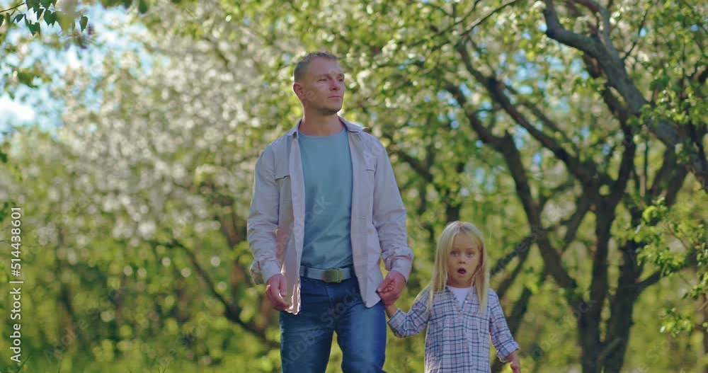 father and daughter are walking in beautiful park in spring, blooming trees in orchard, 4K, Prores father and daughter are walking in beautiful park in spring, blooming trees in orchard, 4K, Prores
