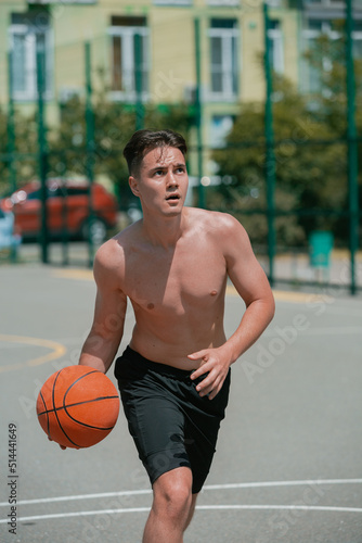 young guy plays basketball on the basketball court. throws the ball into the ring. doing sports. healthy body and healthy lifestyle