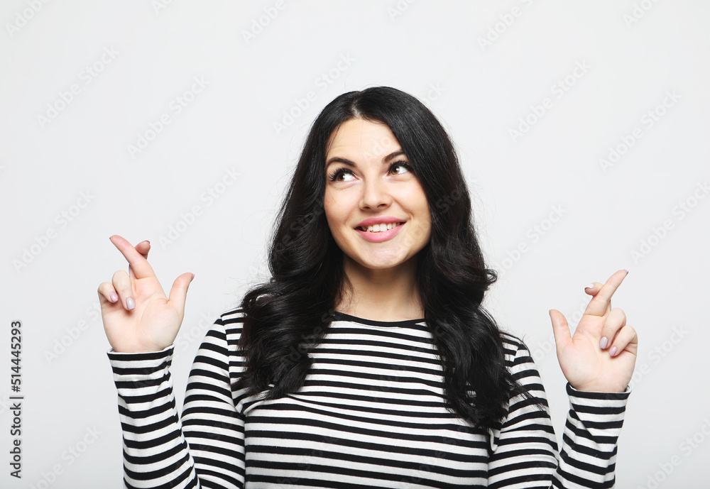Joyful hopeful and charismatic optimistic brunette woman smiling cross fingers for dream come true Joyful hopeful and charismatic optimistic brunette woman smiling cross fingers for dream come true