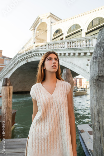 pretty woman in sleeveless jumper looking away near Rialto Bridge in Venice.