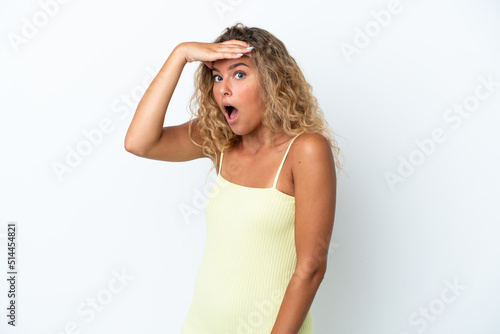 Girl with curly hair isolated on white background doing surprise gesture while looking to the side