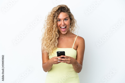 Girl with curly hair isolated on white background surprised and sending a message