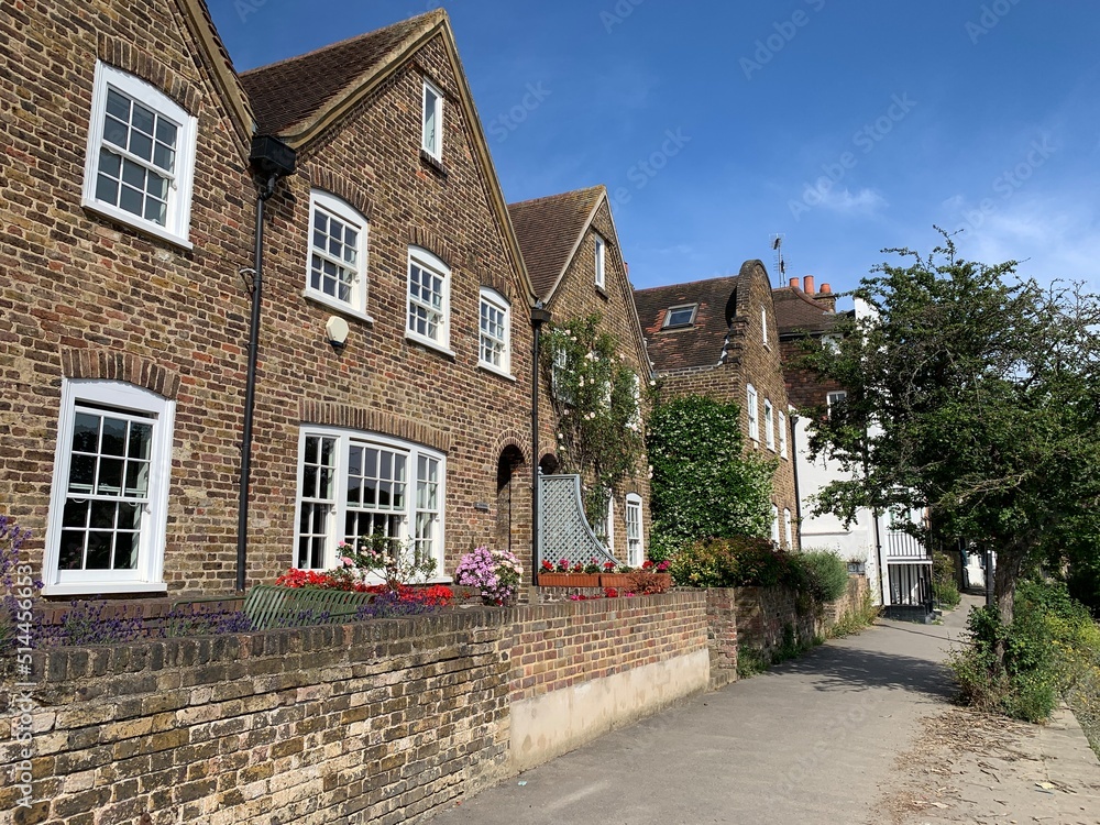 London, England, UK. Strand on the Green street view. Street view of Strand on the Green riverside. Fragment of dutch and english facades with brick wall small cozy front gardens. old town. Chiswick London, England, UK. Strand on the Green street view. Street view of Strand on the Green riverside. Fragment of dutch and english facades with brick wall small cozy front gardens. old town. Chiswick