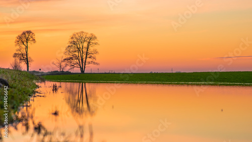 Sunset over the river and tree reflection