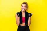 Sport woman with towel isolated on yellow background with thumbs up gesture and smiling