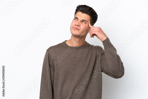 Young handsome caucasian man isolated on white bakcground making the gesture of madness putting finger on the head