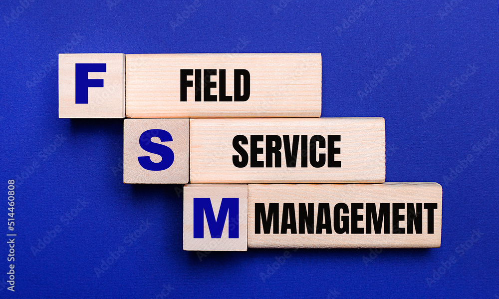 On a bright blue background, light wooden blocks and cubes with the text FSM Field Service Management