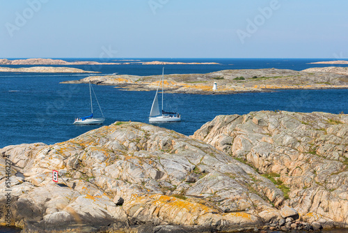 Sailing boats in rocky sea archipelago with a lighthouse