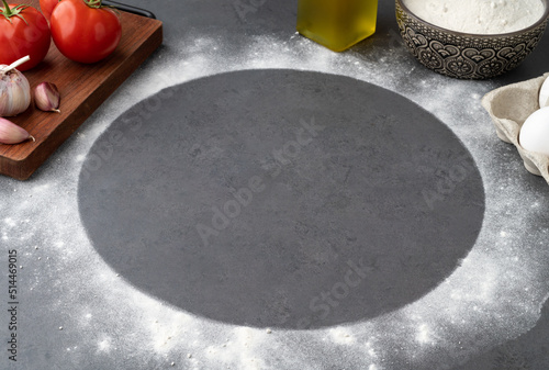 Empty pizza space with tomatoes, eggs and flour over stone background. Pizza negative space