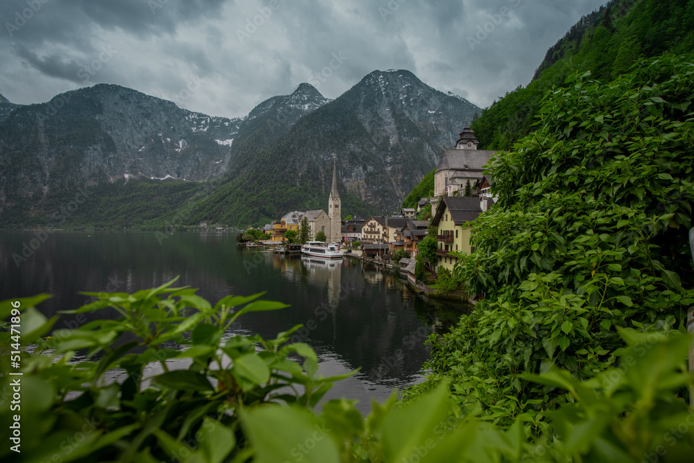 Beautiful view of Hallstatt, Austria, picturesque village on the edge of a lake. Classical view looking through the window in a bush.