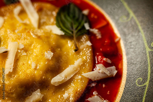 Ricotta ravioli with honey, walnuts and chives in cherry tomato sauce photo