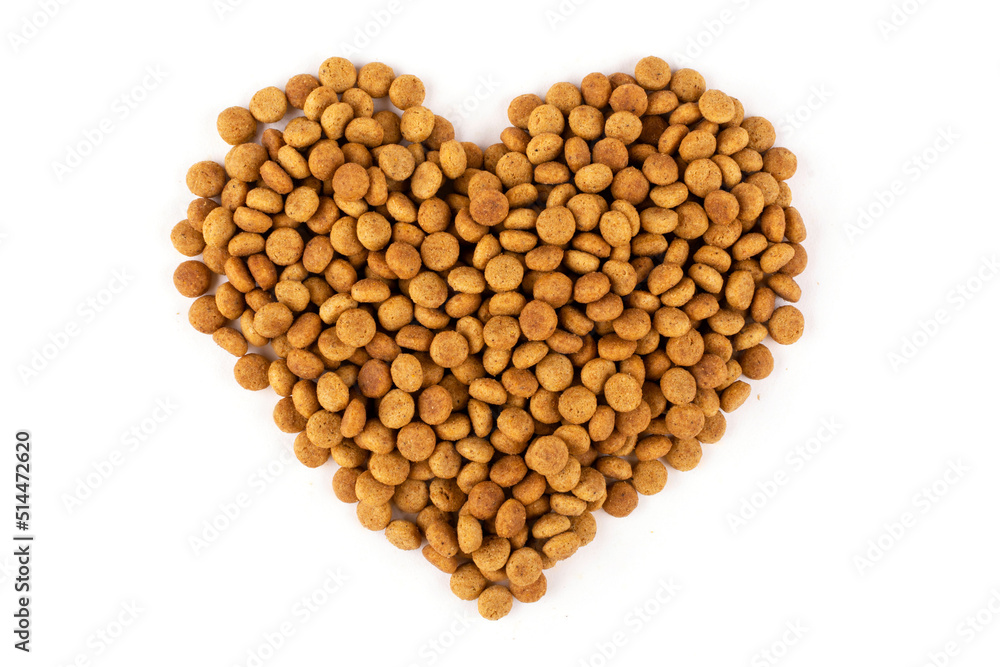 A heart laid out of dry cat food (dogs) on a white isolated background. Balanced nutrition of pets. The cat likes dry food A heart laid out of dry cat food (dogs) on a white isolated background. Balanced nutrition of pets. The cat likes dry food