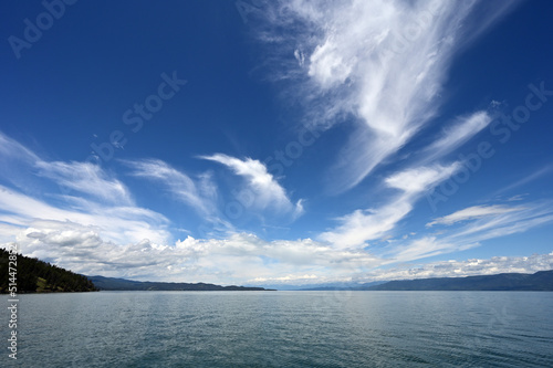 Beautiful dramatic summer cloudscape over Flathead Lake in Montana on calm June day.