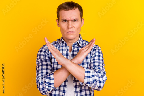 Man isolated on yellow background making stop gesture x crossing hands palms arms