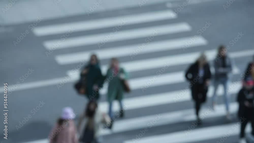 pedestrians cross the road on a zebra crossing in both directions in a blur pedestrians cross the road on a zebra crossing in both directions in a blur