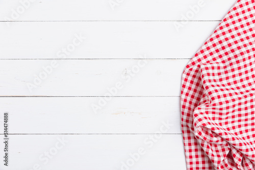 Top view of fabric tablecloth red and white checkered on wooden white table. Flat lay cotton with copy space for text menu to restaurants.