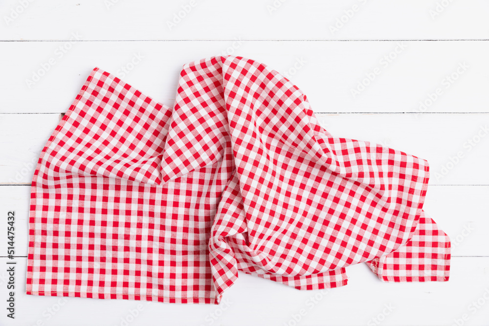 Kitchen red and white checkered tablecloth on white wooden empty space background. Red and white checkered fabric pattern.