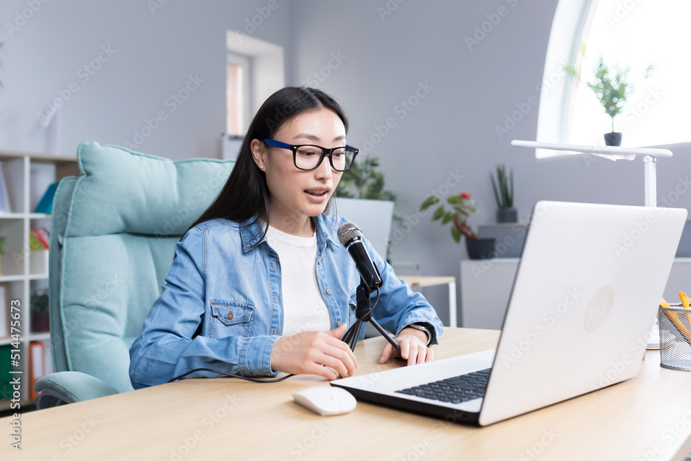 Young beautiful Asian woman recording audio podcast, woman in office using professional microphone Young beautiful Asian woman recording audio podcast, woman in office using professional microphone