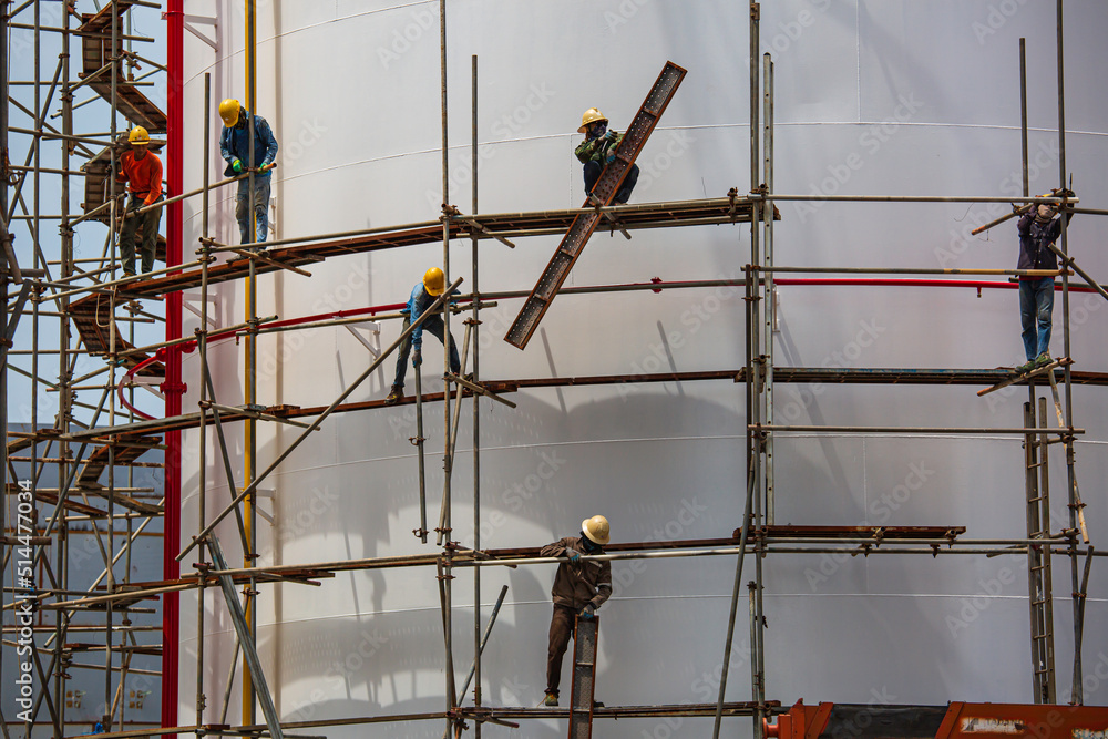 Worker male assembly in progress storage new tank oil inspection scaffolding Worker male assembly in progress storage new tank oil inspection scaffolding