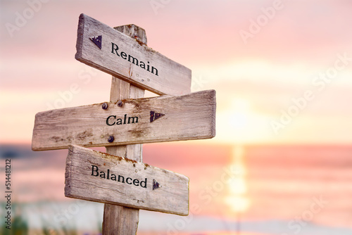 remain calm balanced text quote on wooden crossroad signpost outdoors on beach with pink pastel sunset colors. Romantic theme.
