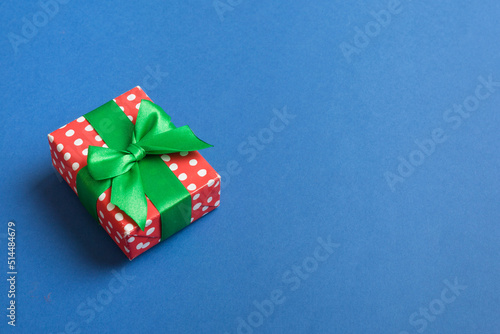 Wrapped christmas or other holiday handmade present in paper with colored ribbon. Present box, decoration of gift on table, top view with copy space © sosiukin