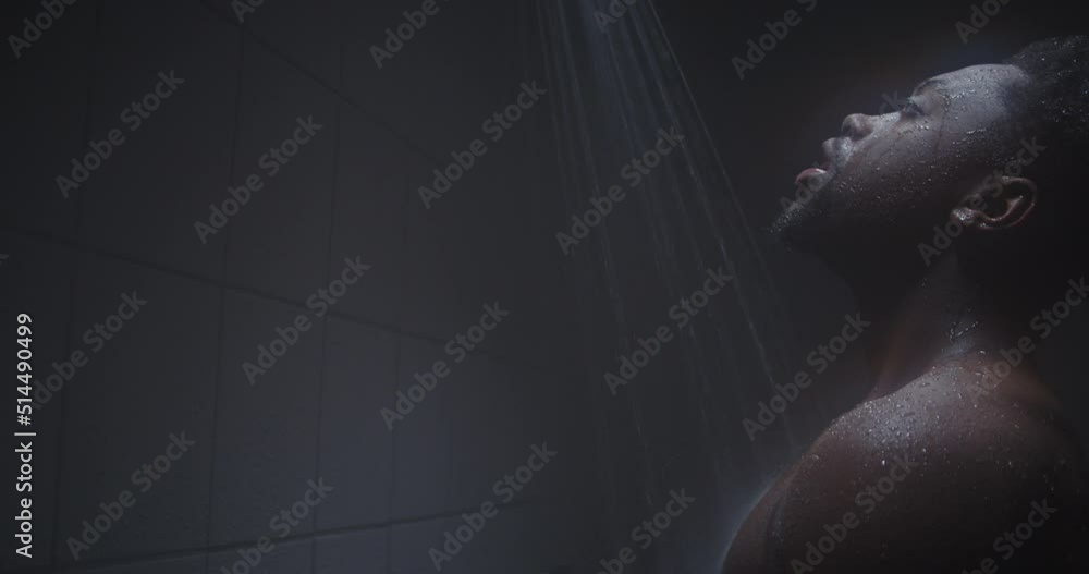 Muscular young black athlete taking a shower in the gym. Muscular young black athlete taking a shower in the gym.