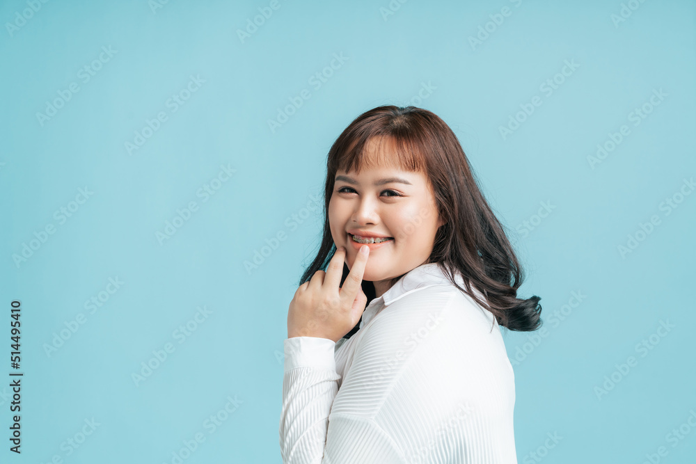Portrait beautiful confidence Asian woman plus size happy smile on isolate light blue studio background. Young female chubby confident concept. Portrait beautiful confidence Asian woman plus size happy smile on isolate light blue studio background. Young female chubby confident concept.
