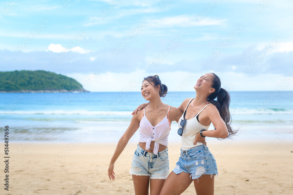 Two attractive women friends enjoying and relaxing on the beach,  Summer, vacation, holidays, Lifestyles concept.